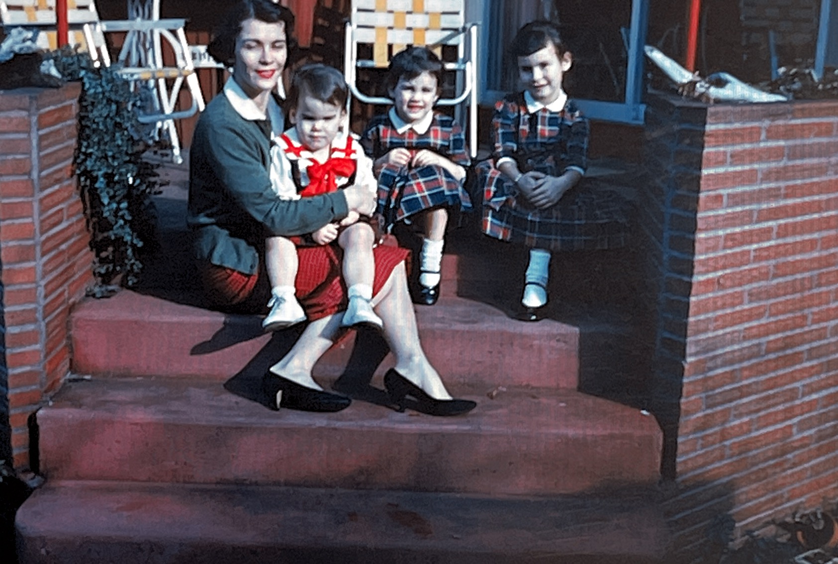 This picture was taken in Tacoma, Washington  on my Grandparents back porch steps in the Spring of 1959.  This picture is of myself  (Debbie Jardeen) sitting on my Mom’s (Dolores Jardeen) lap with my two sisters (Lynne Jardeen and Cheryl Jardeen).