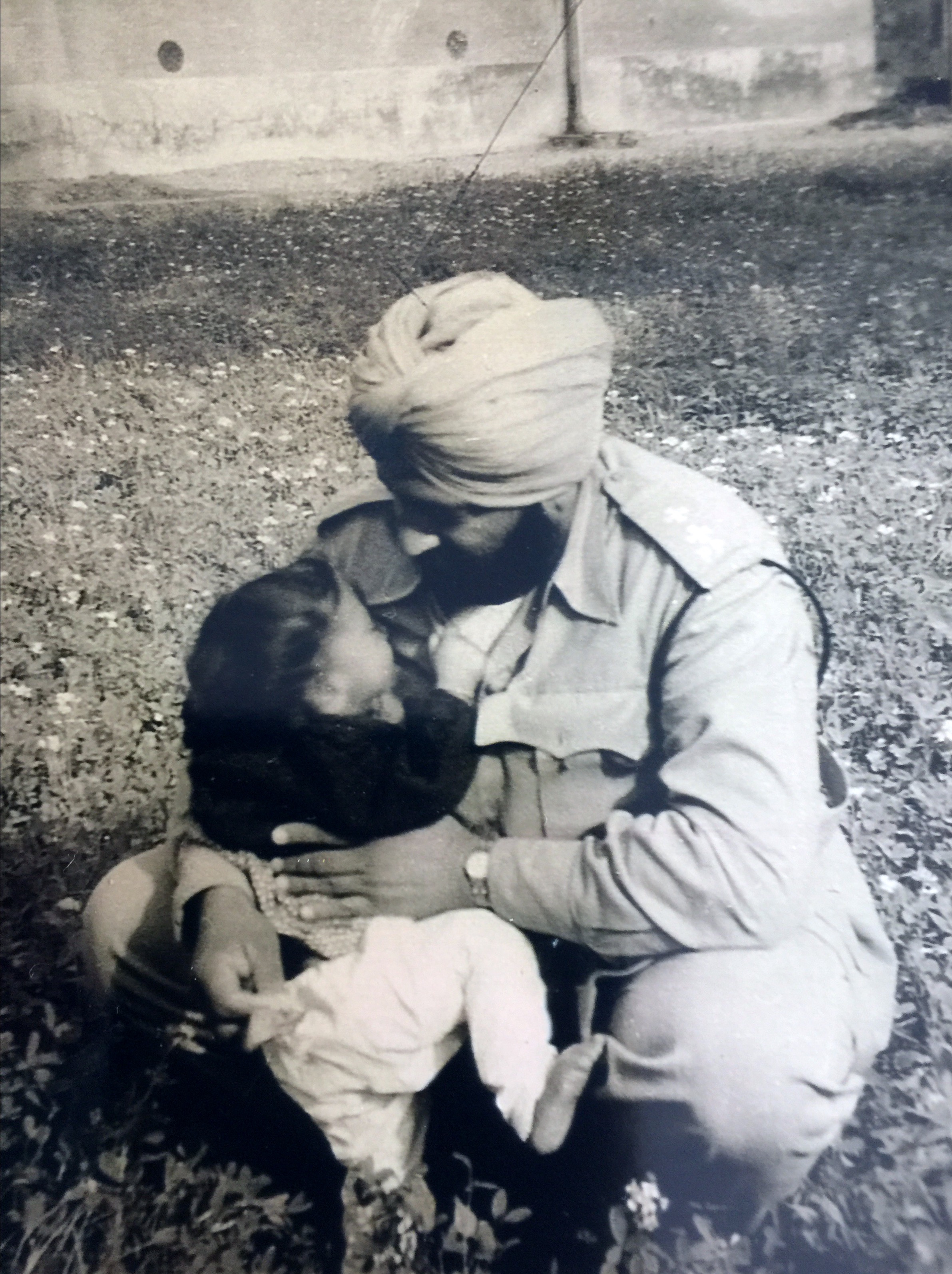 Little JagMohan trying to climbing into dad's lap. 1950?