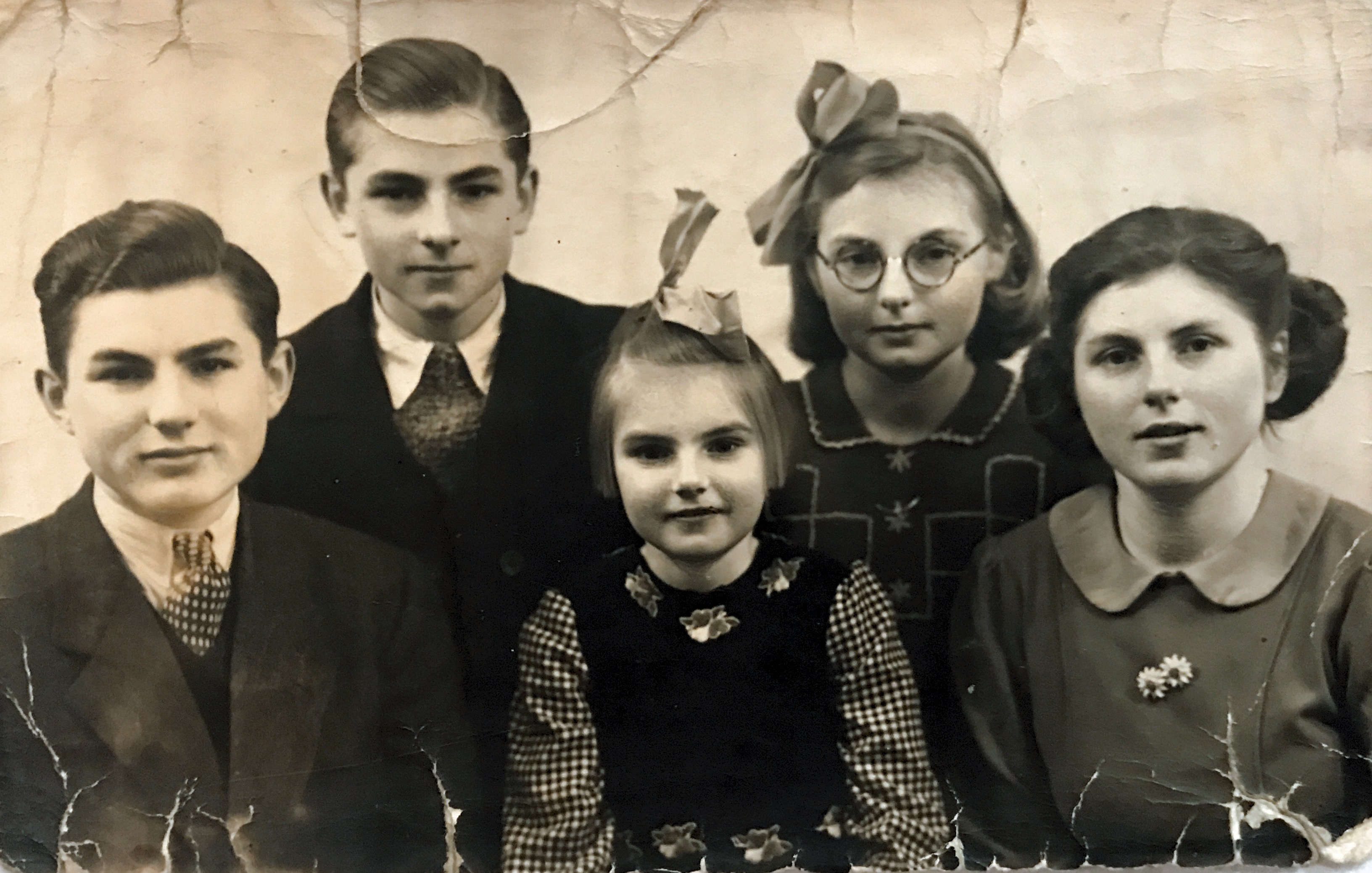 The van Schoonhoven Family: Pieter (15), Dirk (13), El (5), Jol (9), Rie (19), (1940?)
Not pictured:
Father: Dirk Jacobus van Schoonhoven
Mother: Johanna Kolk

The child second from the left and in the back row is Dirk Jacobus van Schoonhoven (named after his father) in a professional family photo with his siblings.  They lived in Rotterdam, Netherlands.   The picture was taken in 1940 just before the German occupation. It is the only picture we have so far that is of him at this age (or any childhood picture). It’s a treasure to us!  
Months after this picture was taken their mother Johanna Kolk van Schoonhoven died (which saddened Dirk tremendously) and the invasion disrupted their lives.

