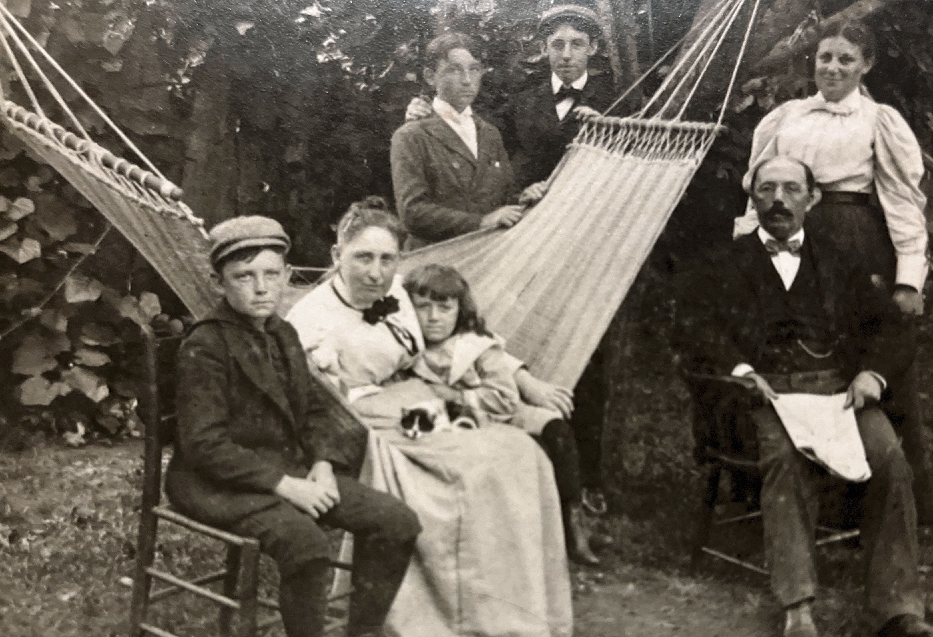  The man seated on the right is Thomas Thompson (?) Allan,  Grandpa’s (Kenneth T’s) dad.  Lady behind him is, Helen, his sister(20),  one of the boys behind the Hammock is James (18), the other, William (16).  His mom, Catherine Nesbit Allan is seated on the hammock.  The boy next to her is Douglas (13) and the young child with the long hair is Grandpa (6).