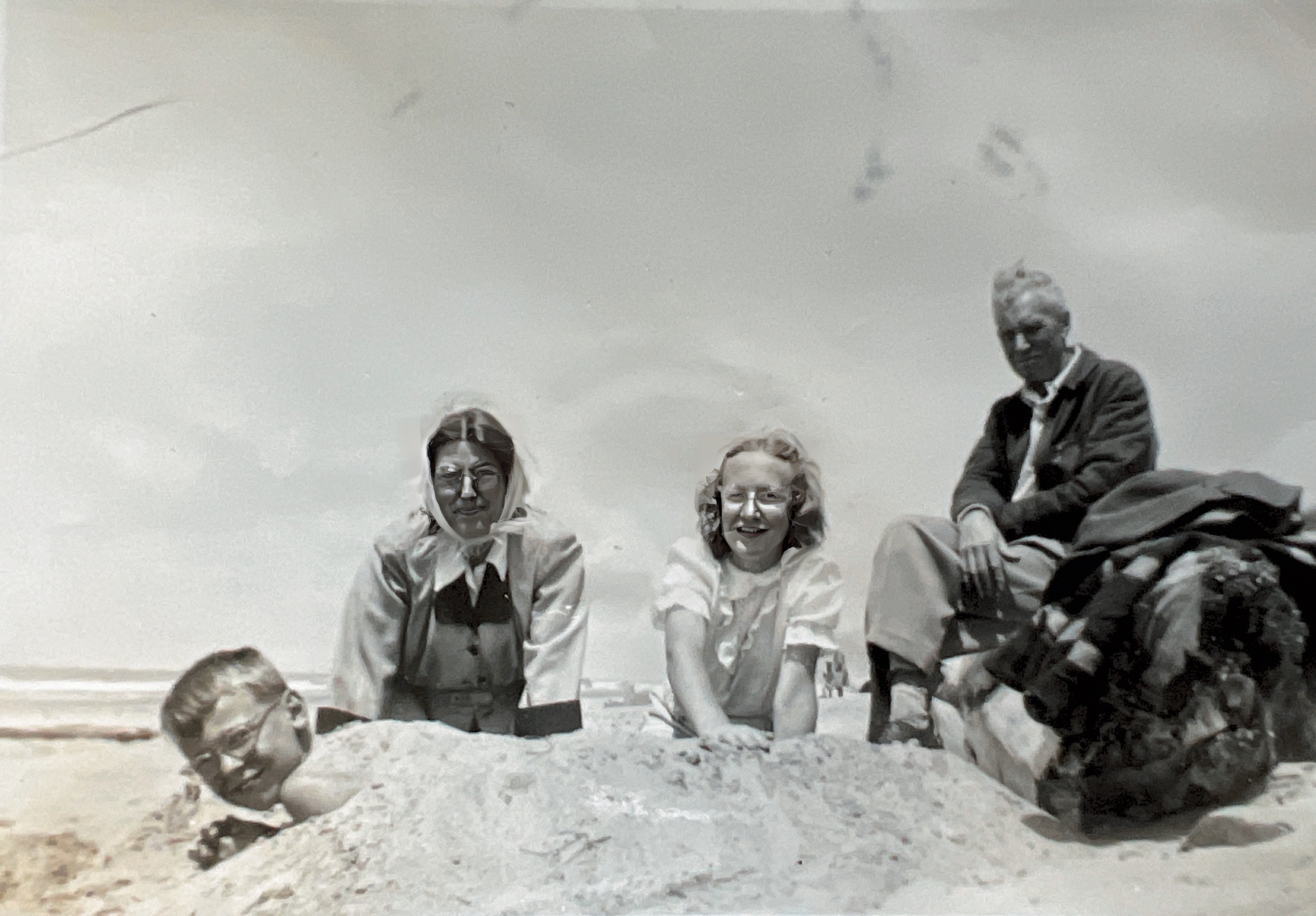 David (being buried), Gretchen, Sue Ann, and Paul Sadler at the beach in Lincoln City, Oregon. July 4, 1950