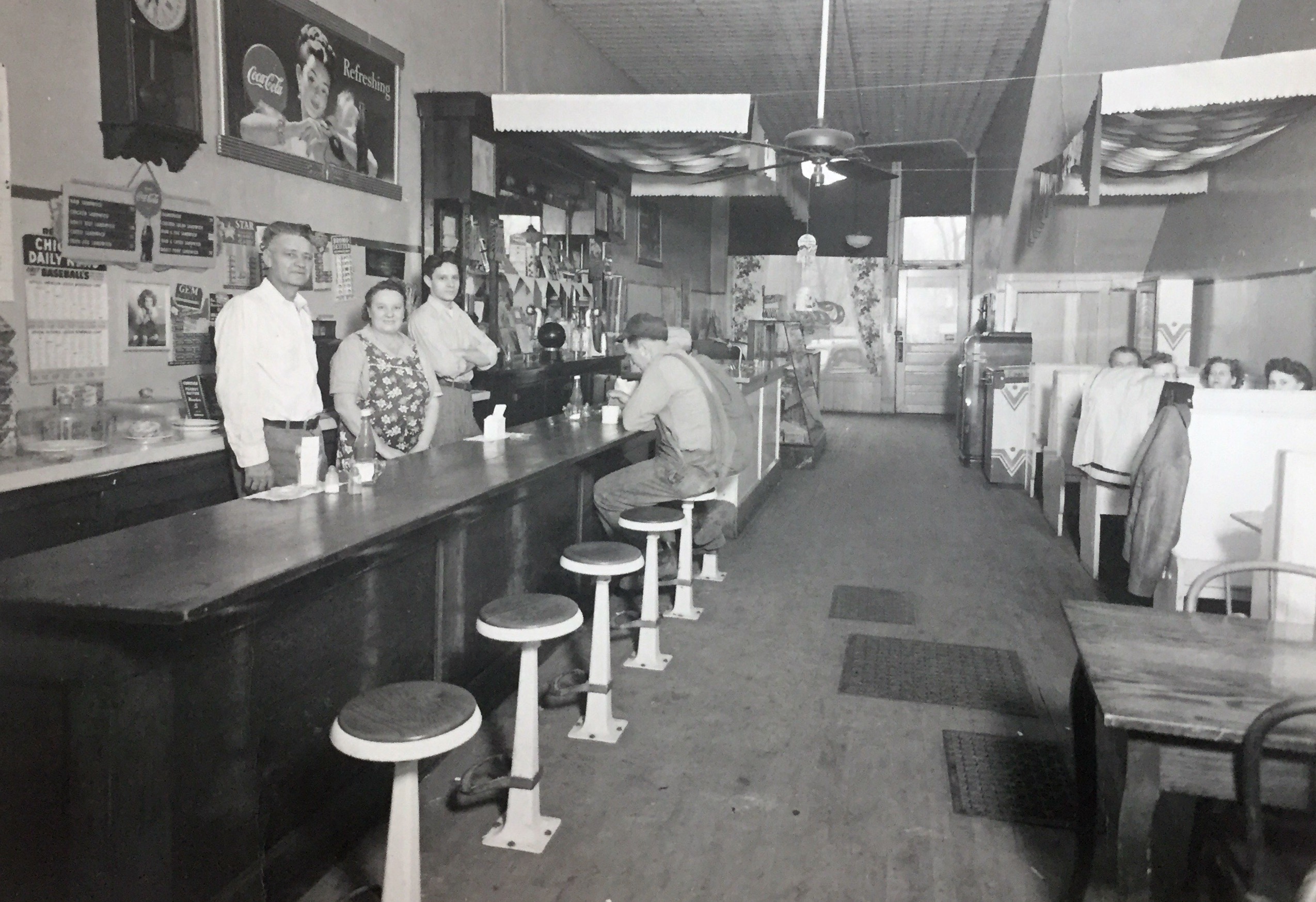 Grandpa and Grandma Bradley behind the counter in their diner. Uncle Pete behind them. Around 1950.