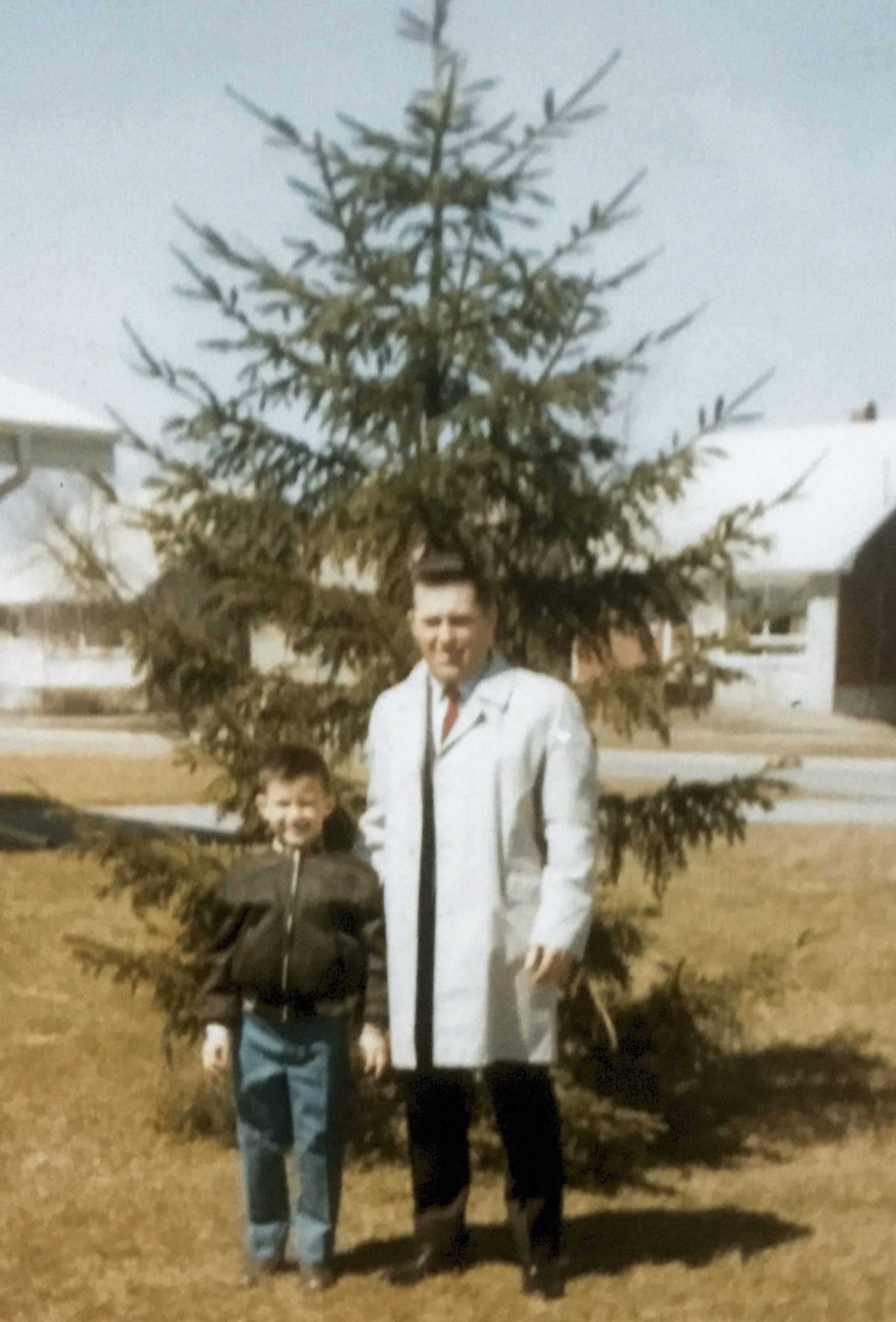 Taken in 1970 at 129 Catherine Street in Fort Erie, Ontario. My dad and I in front of a tree he had recently transplanted. The tree still stands. I was 7 years old at the tie of the photo.