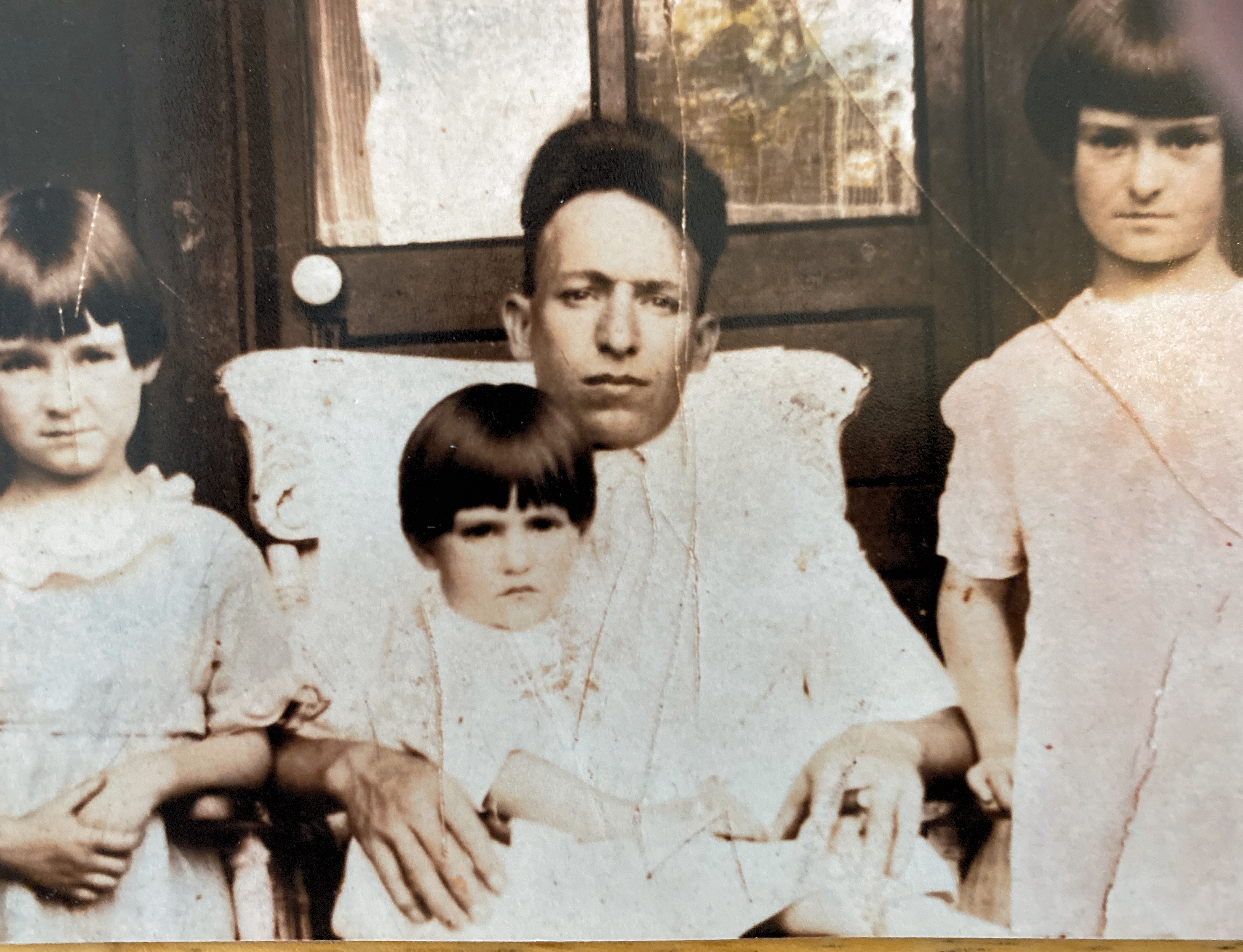 My mother sitting on her fathers lap. Flanked by her older sisters on Knoxville,Tennessee. Early 1920’s